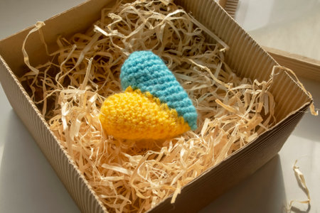 Knitted heart of yellow and blue flowers in a gift box. gift - the heart of the colors of the flag of Ukraine. The symbol of Ukraine is a yellow-blue heart in a gift box in tinsel.の写真素材
