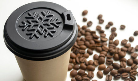 winter cup among coffee beans. A plastic cup among coffee beans. Plastic cover about a snowflake on a coffee cup.の写真素材