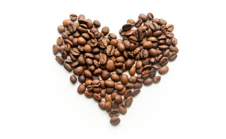 a heart made of coffee beans. On a white background is a silhouette of a heart made of coffee beans. Love of coffee.の写真素材