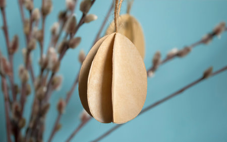 paper eggs hang on willow branches for Easter. DIY crafts bulky paper eggs as a toy on a twig. Decorations for the house eggs made of paper for Easter.の写真素材