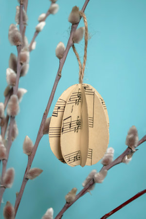 paper eggs hang on willow branches for Easter. DIY crafts bulky paper eggs as a toy on a twig. Decorations for the house eggs made of paper for Easter.の写真素材