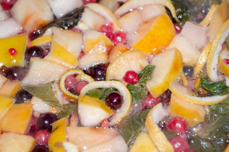 Currant berries, apples and mint leaves in compote. Preparation of compote from fruits, berries and green leaves. Useful compote.の写真素材