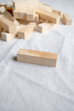 Bars of wooden construction set on linen fabric. On the tablecloth are pieces of wooden construction set.の写真素材