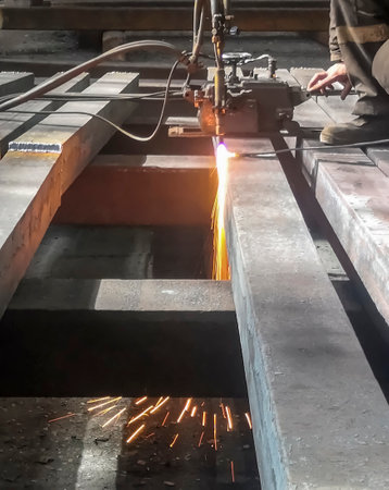 Metallurgical plant - metal processing. The workpiece is processed by a gas-cutting machine. Cutting a square before processing and sorting. Steel production at the plant.の写真素材