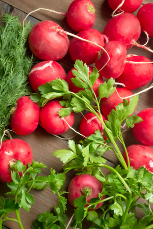 Radishes and parsley on a wooden table. Healthy spring vegetables. Green parsley with bright radishes.の写真素材