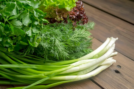 Green onions, lettuce, dill and parsley on a wooden table. Healthy greens in the spring for salad. Delicious greens are seasonal. cultures for cooking.の写真素材