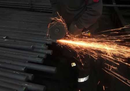 cutting metal with a grinder. metallurgy. Work at a foundry metallurgical plant. Work in the factory - cutting a square.の写真素材