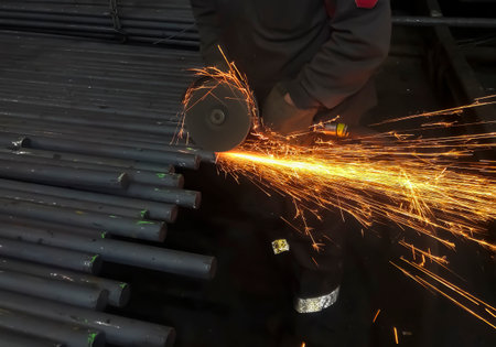 cutting metal with a grinder. metallurgy. Work at a foundry metallurgical plant. Work in the factory - cutting a square.の写真素材