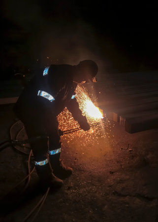 The process of cutting metal with a gas machine. metallurgy. Work at a foundry metallurgical plant. An employee of the plant processes metal. Processing of finished metal for further shipment.の写真素材
