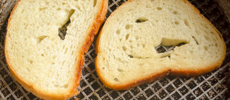 Toast in a pan. Grilled bread in a frying pan. Bread with a golden crust after frying.の写真素材