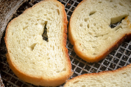Toast in a pan. Grilled bread in a frying pan. Bread with a golden crust after frying.の写真素材