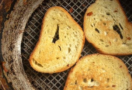 Toast in a pan. Grilled bread in a frying pan. Bread with a golden crust after frying.の写真素材