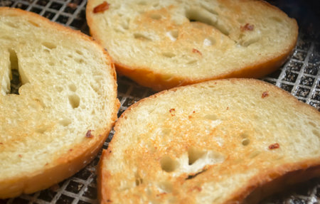 Toast in a pan. Grilled bread in a frying pan. Bread with a golden crust after frying.の写真素材