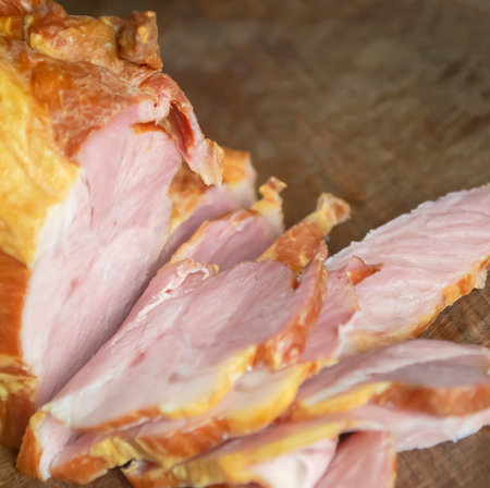 Pork slicing. A piece of smoked balyk on a wooden board. Smoked pork belly in section.の写真素材