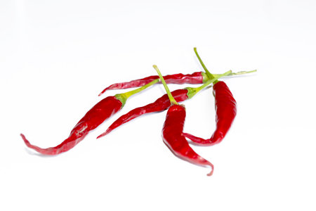 A lot of hot peppers on a white background. A few chili peppers on white. Pepper is red with green tails. hot pepper.の写真素材