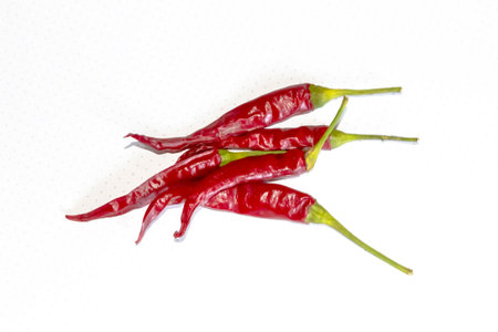 A lot of hot peppers on a white background. A few chili peppers on white. Pepper is red with green tails. hot pepper.の写真素材
