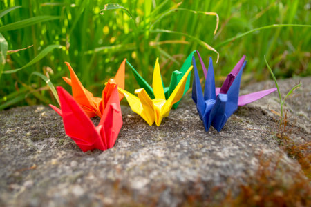 Paper cranes of LGBTQ colors together. The concept of equality and freedom through paper cranes. Flag LGBT community paper cranes in nature.の写真素材