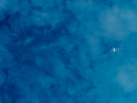 A young moon in a bright evening sky. The month rose in the early evening. the moon in the blue sky.