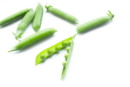 Open pod with peas inside. Green peas in a pod on a white background. Green pea pods on a white background.の写真素材