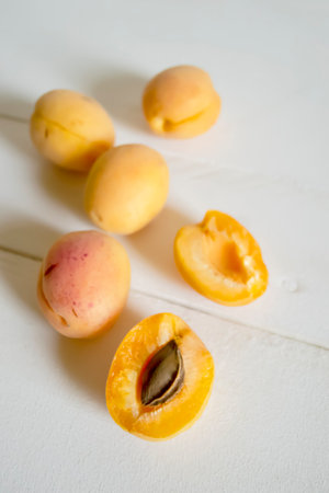 Fresh apricots on a wooden table. Summer fruits are juicy apricots. Orange large apricots on a white table.の写真素材
