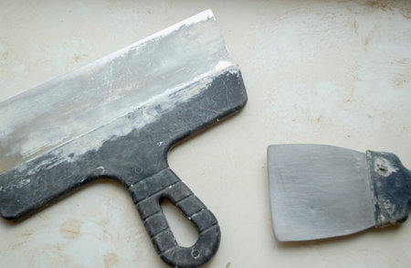 On a dirty white background, two repair spatulas. Two spatulas lie on a dirty table.の写真素材