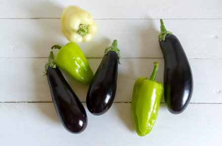 On a white table eggplant and bell peppers. Bell peppers and eggplant on the table. Summer...