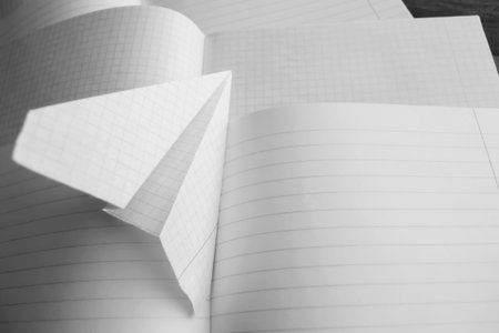 Self-made of paper on open school notebooks. On the open notebooks is a paper plane.の写真素材