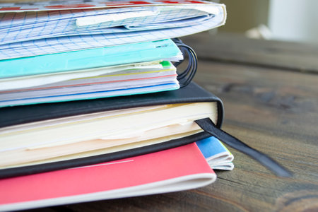 A stack of notebooks close-up. notebooks on a spring lie on top of each other. A few notebooks on a wooden table. Notebooks for work and accounts.の写真素材