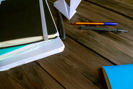 On a wooden table are notebooks, notebooks and pens. Marketing, business, training - notebooks and...