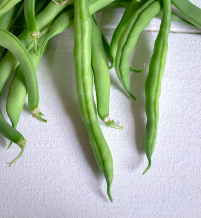 On a white table are bean bean pods. Bean asparagus on white for summer dishes.の写真素材