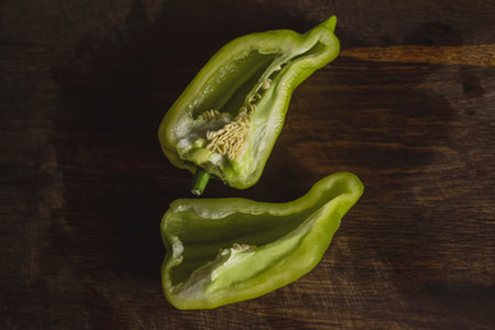 Bell pepper two halves with seeds on a wooden table. Two halves of sweet pepper.の写真素材