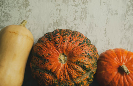 Autumn decorations - three decorative pumpkins against the background of old walls. Three pumpkins on the background of an old wall.の写真素材