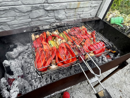 Vegetable barbecue. BBQ Bell peppers and mushrooms are fried on the grill. Mushrooms, peppers. is roasted in the yard on a fire.の写真素材