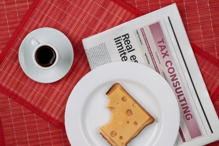  breakfast business person on the table close-up cup of black coffee and a sandwich with cheese newspaperの写真素材