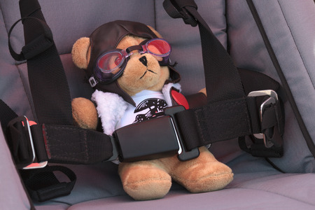 Teddy bear sitting in a chair dressed as a pilotの写真素材