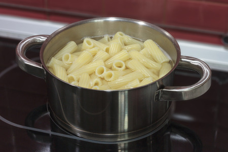 Boiled the pasta in the pan on the hotplate in the interiorの写真素材