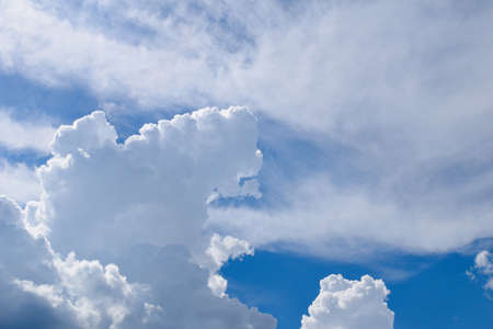 Fluffy white clouds against a blue skyの写真素材