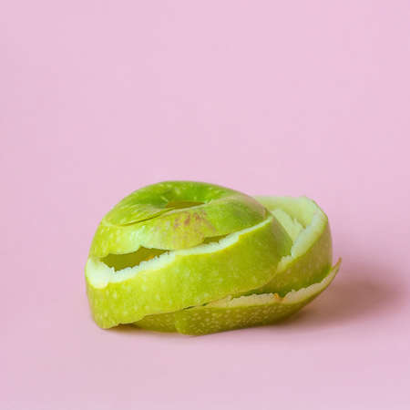 green apple peel on pink background as a symbol of recycling circulate economyの写真素材