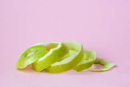 green apple peel on pink background as a symbol of recycling circulate economyの写真素材