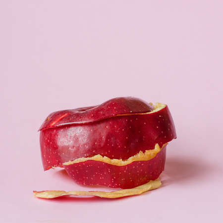 Red apple peel on pink background as a symbol of recycling circulate economy
