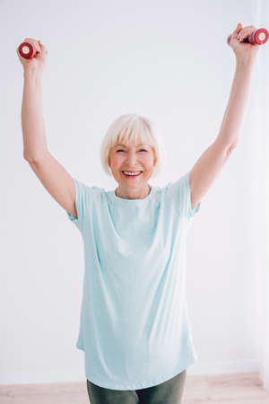 senior cheerful woman doing sports with dumbbells. Anti age, sports, healthy life style concept