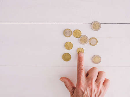 senior hands counting euro coins on the table. poverty, crisis, deposit, recession concept