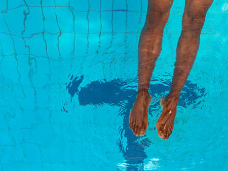 adult African American man's legs underwater in swimming poolの写真素材