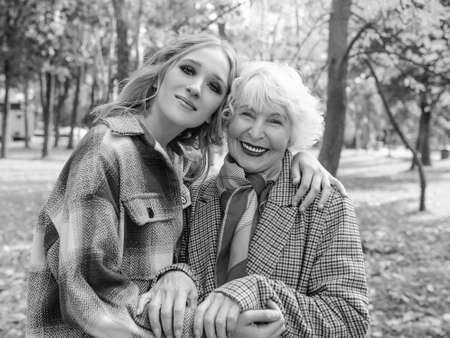 Monochrome portrait of senior woman with young daughter walking outdoor in spring. Family, generation, care, love, vaccination conceptの写真素材