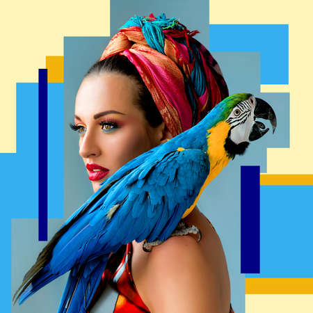 Portrait of young attractive woman in african style with ara parrot on her showlder on colorful...