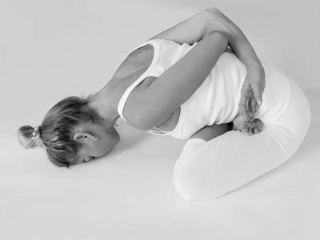 monochrome portrait of caucasian blonde beautiful cheerful woman doing yoga asanas. Healthy...