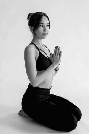 monochrome portrait of caucasian brunette beautiful cheerful woman doing yoga asanas. Healthy lifestyle and sport conceptの写真素材