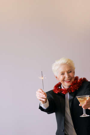 stylish mature senior woman in tuxedo celebrating new year. Fun, party, style, celebration conceptの写真素材