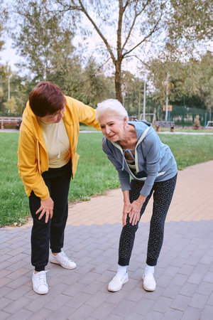 two senior women doing sports in the park, heart attackの写真素材
