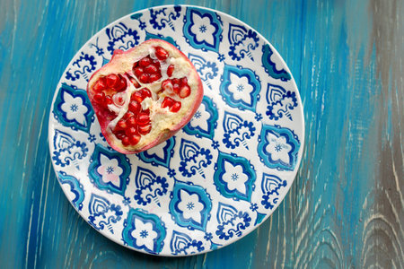 Garnet on plate with blue and white pattern on wooden background